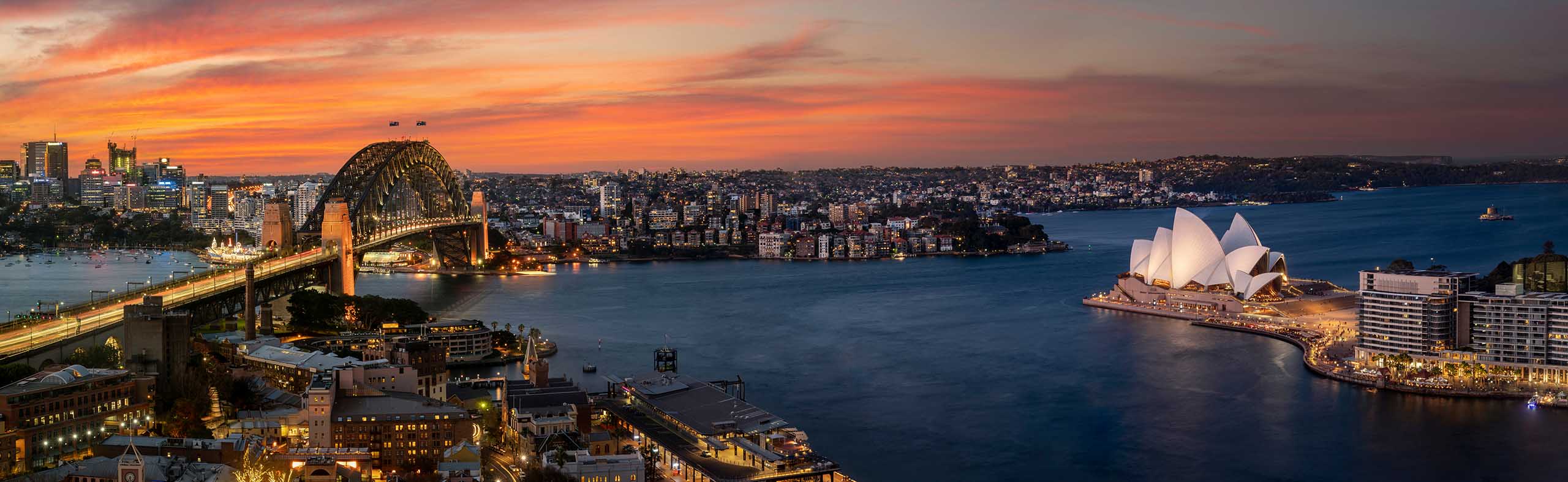 Cityscape image of Sydney, Australia with Harbour Bridge and Sydney skyline during sunset.