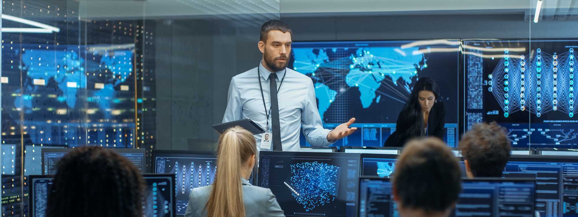 Chief Project Engineer Holds Briefing for a Team of Scientists that are Building Machine Learning System. Displays Show Working Model of Neural Network.